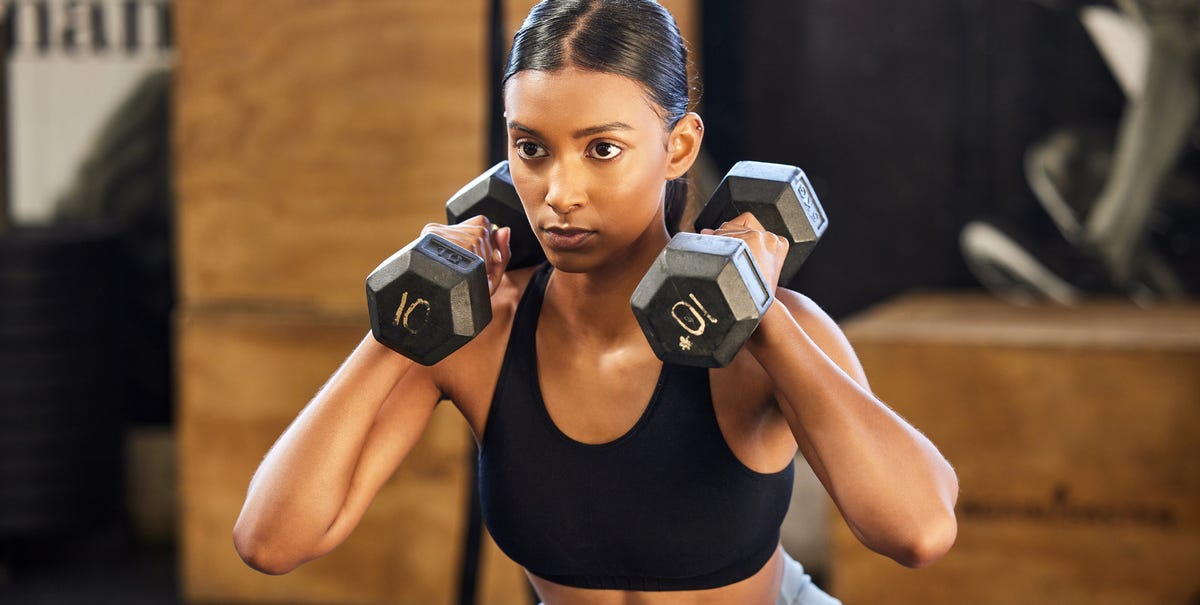 Heres How Many Days a Week You Need To Work Out Based On Your Goal (Weight Loss vs Building Muscle) - Womens Health 1 shot of a young woman working out with weights in a royalty free image 1705679985
